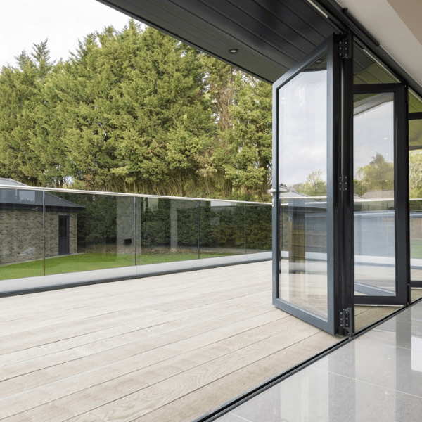 Bifold doors open onto a deck with glass balcony